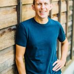 Paul standing against wood wall
